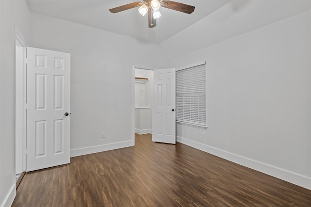 unfurnished bedroom with ceiling fan and dark wood-type flooring