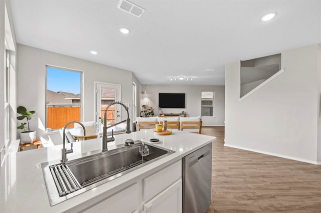 kitchen with dishwasher, white cabinets, light hardwood / wood-style floors, and sink