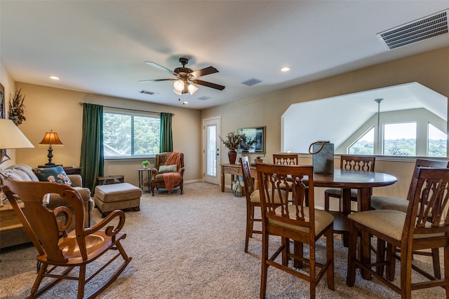 carpeted dining area featuring ceiling fan, a healthy amount of sunlight, and vaulted ceiling