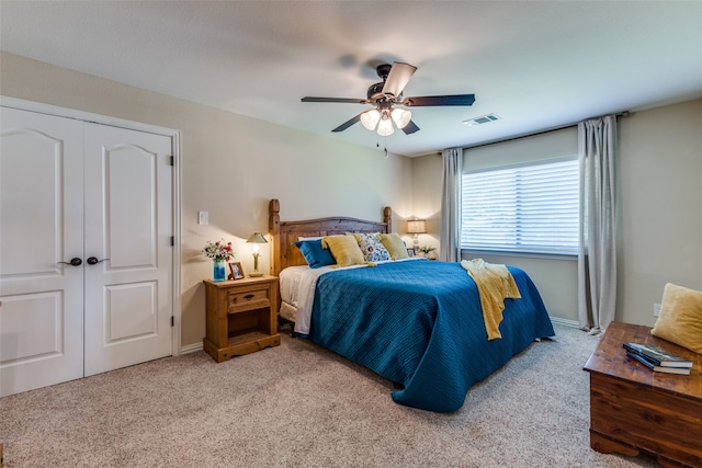 bedroom with ceiling fan, a closet, and light carpet