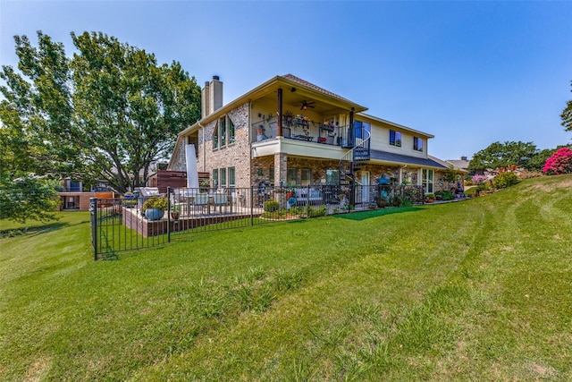 rear view of property featuring a lawn, ceiling fan, and a balcony