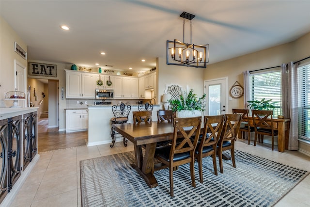 dining area featuring sink, light tile patterned floors, and an inviting chandelier