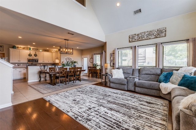 living room featuring high vaulted ceiling and light wood-type flooring