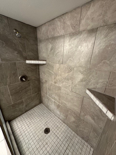 bathroom featuring a tile shower and a textured ceiling