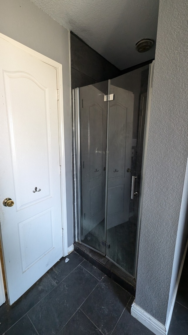 bathroom with tile patterned floors and an enclosed shower