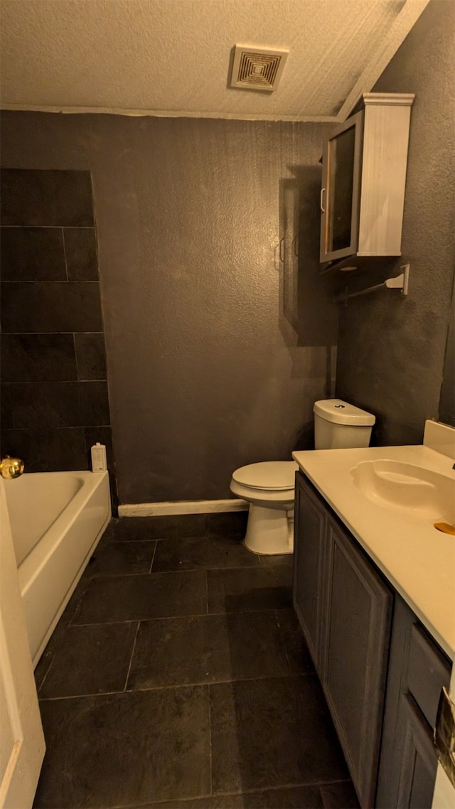 bathroom featuring a textured ceiling, vanity, toilet, and tile patterned floors