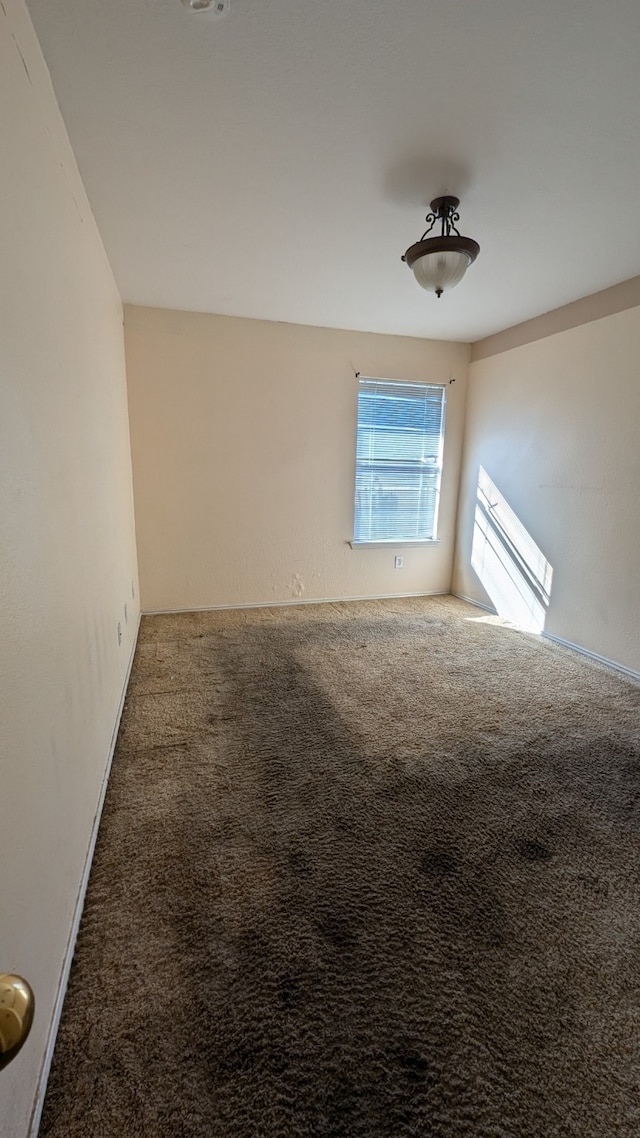 spare room featuring dark colored carpet