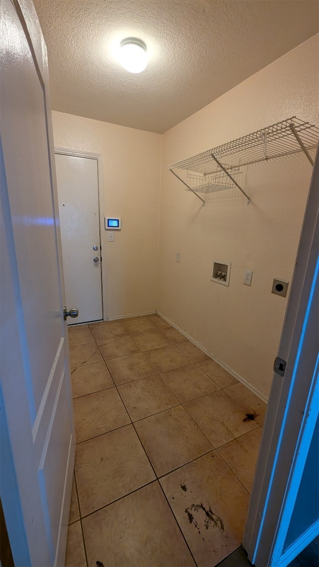 washroom featuring electric dryer hookup, hookup for a washing machine, a textured ceiling, and tile patterned flooring