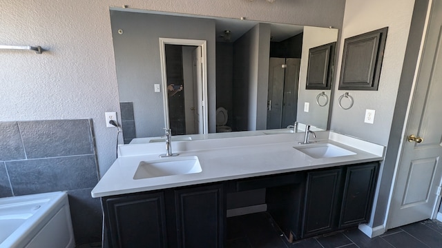 bathroom with a bathing tub, tile patterned flooring, and vanity