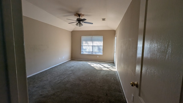 empty room with ceiling fan, dark carpet, and vaulted ceiling