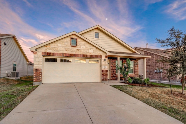 craftsman-style house featuring a lawn, central AC, and a garage