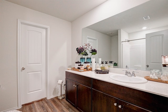 bathroom with vanity, wood-type flooring, and walk in shower