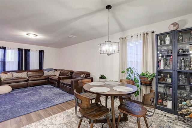 dining space featuring hardwood / wood-style flooring and a notable chandelier