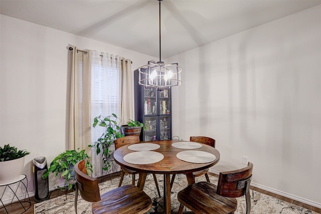 dining area featuring wood-type flooring and an inviting chandelier