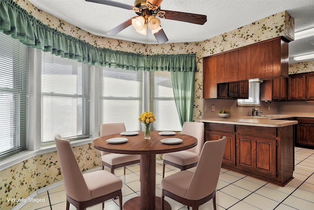 kitchen with plenty of natural light, sink, light tile patterned floors, and a textured ceiling