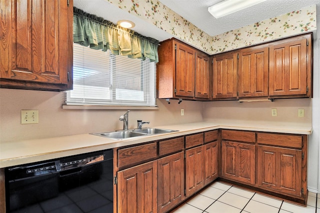 kitchen featuring a textured ceiling, dishwasher, light tile patterned floors, and sink