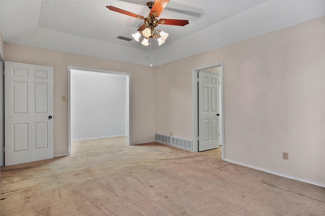 unfurnished room featuring ceiling fan, light colored carpet, and a textured ceiling