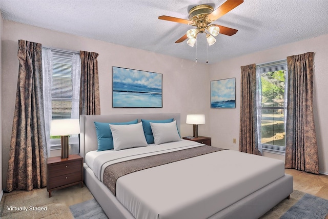 carpeted bedroom with ceiling fan and a textured ceiling