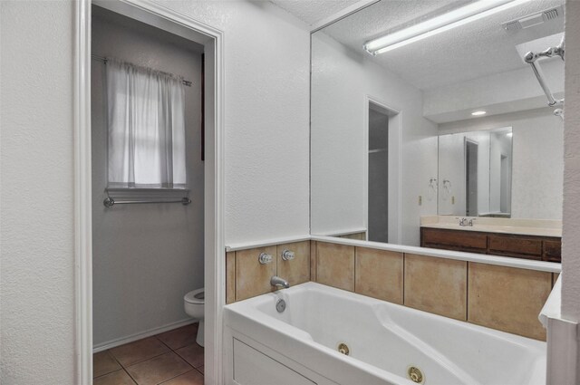 bathroom featuring a tub, tile patterned flooring, a textured ceiling, and toilet