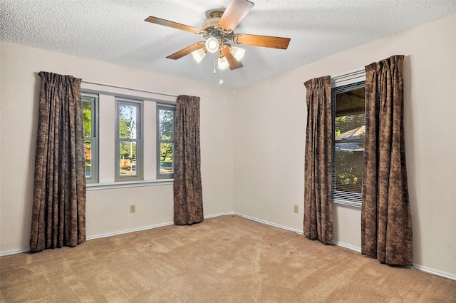 empty room featuring light carpet, a textured ceiling, and ceiling fan