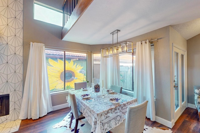 dining space featuring a textured ceiling, dark hardwood / wood-style flooring, and a wealth of natural light