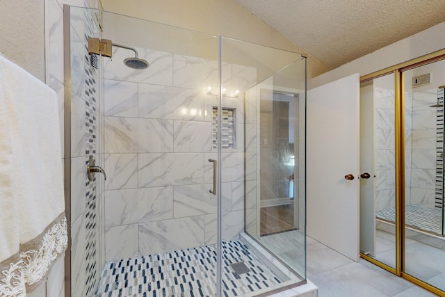 bathroom featuring tile patterned flooring, a shower with door, and a textured ceiling