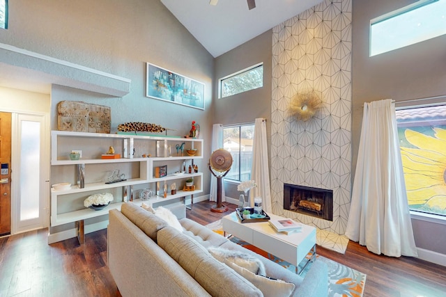 living room with high vaulted ceiling, dark wood-type flooring, and a tiled fireplace