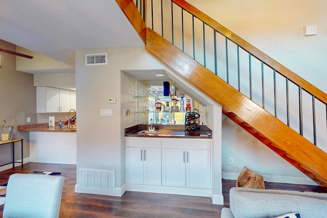 bar featuring white cabinetry, sink, and dark wood-type flooring