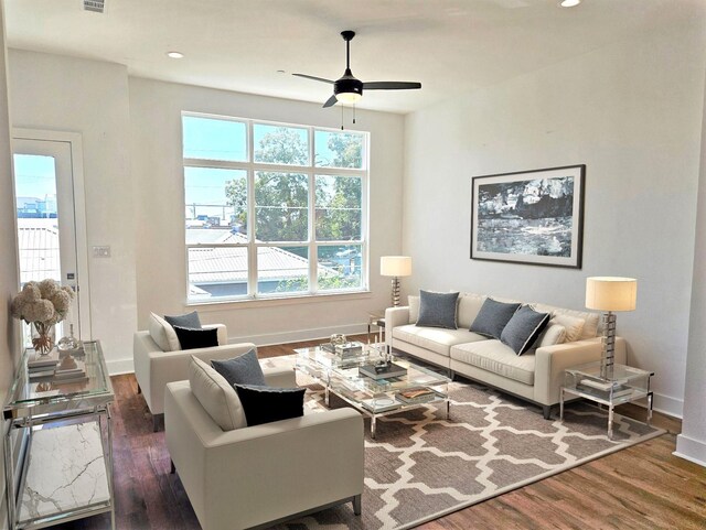 living room with ceiling fan, a healthy amount of sunlight, and dark wood-type flooring