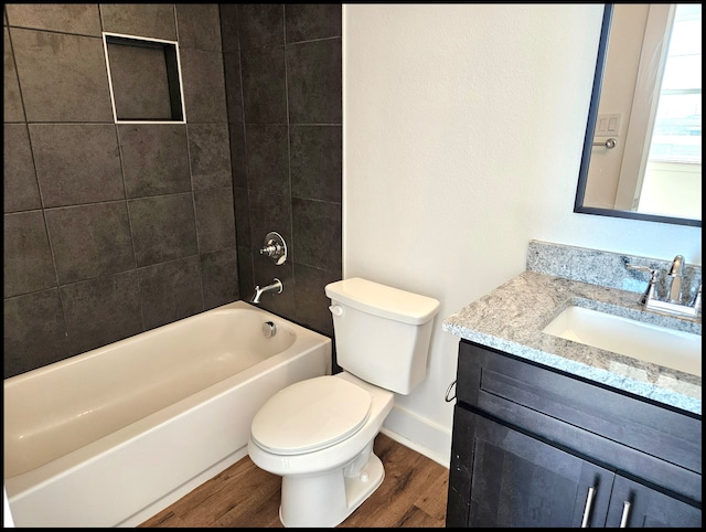 full bathroom with vanity, toilet, wood-type flooring, and tiled shower / bath