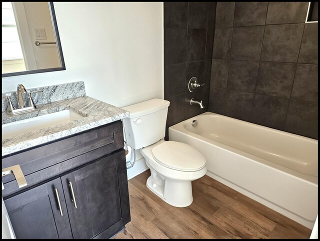 full bathroom featuring vanity, toilet, wood-type flooring, and tiled shower / bath combo