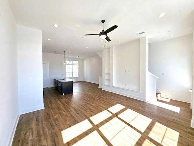 unfurnished living room featuring dark hardwood / wood-style floors and ceiling fan