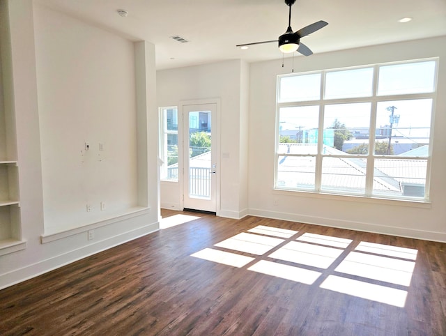 unfurnished room with ceiling fan and dark wood-type flooring