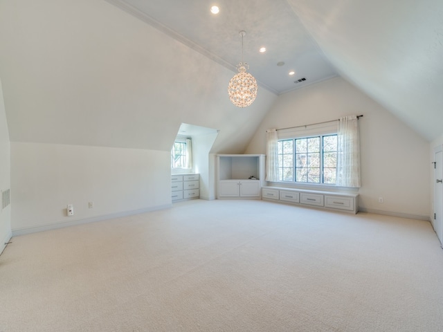 bonus room with a chandelier, light colored carpet, and lofted ceiling