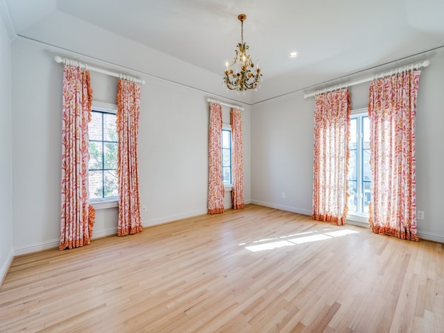 empty room with a chandelier and light hardwood / wood-style floors