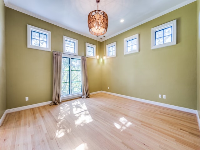 unfurnished room featuring crown molding, an inviting chandelier, and light wood-type flooring