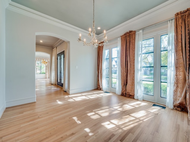 unfurnished dining area featuring light wood-type flooring, ornamental molding, and a wealth of natural light