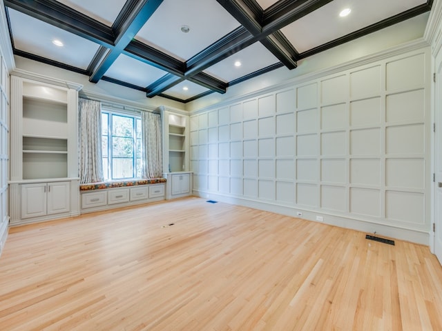 unfurnished room featuring built in shelves, light wood-type flooring, crown molding, and coffered ceiling