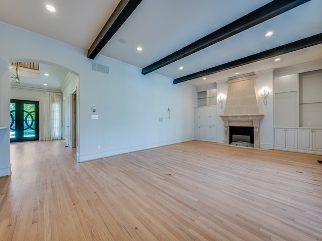 unfurnished living room with beamed ceiling, crown molding, a high end fireplace, and light hardwood / wood-style flooring