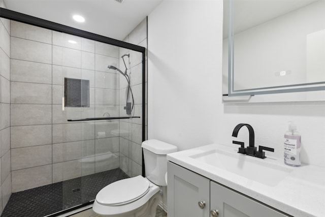 bathroom with walk in shower, vanity, and toilet