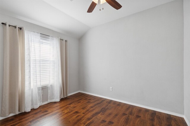 empty room with ceiling fan, dark hardwood / wood-style flooring, a wealth of natural light, and vaulted ceiling