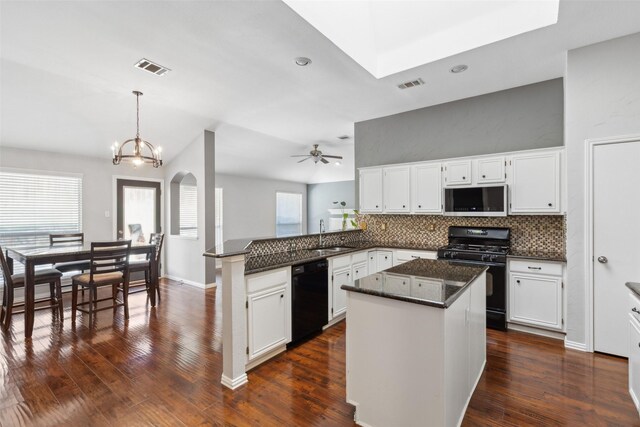 kitchen featuring kitchen peninsula, white cabinets, hanging light fixtures, and black appliances