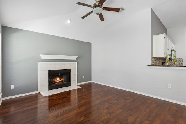 unfurnished living room with a tile fireplace, ceiling fan, lofted ceiling, and hardwood / wood-style flooring