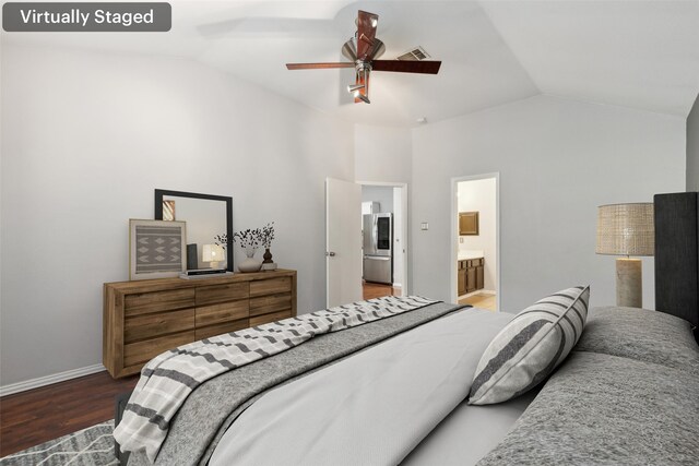 bedroom featuring lofted ceiling, dark wood-type flooring, ensuite bathroom, ceiling fan, and stainless steel fridge