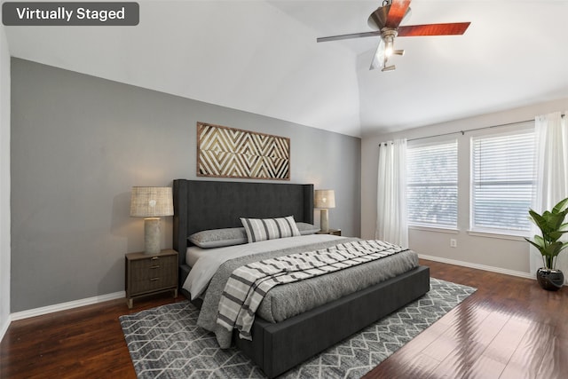 bedroom featuring dark hardwood / wood-style flooring, vaulted ceiling, and ceiling fan