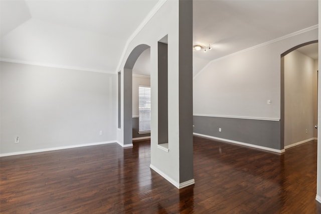 empty room featuring lofted ceiling, crown molding, and dark hardwood / wood-style floors