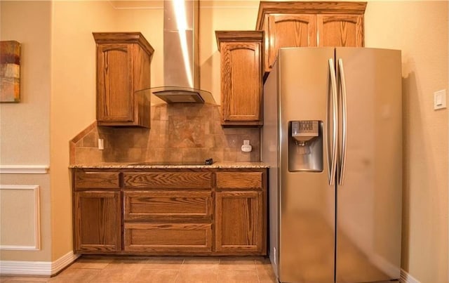 kitchen with wall chimney range hood, backsplash, stainless steel fridge, black electric stovetop, and light tile patterned flooring