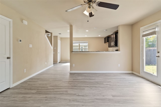 unfurnished living room featuring ceiling fan, plenty of natural light, and light hardwood / wood-style floors