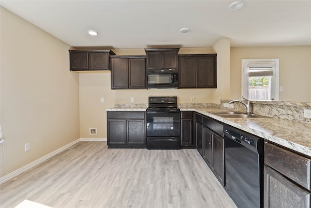 kitchen featuring black appliances, dark brown cabinets, sink, and light hardwood / wood-style flooring