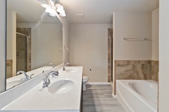 full bathroom with hardwood / wood-style flooring, vanity, toilet, and independent shower and bath